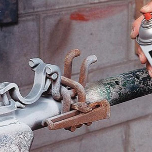 Grey protective coating being sprayed onto metal pipe fittings