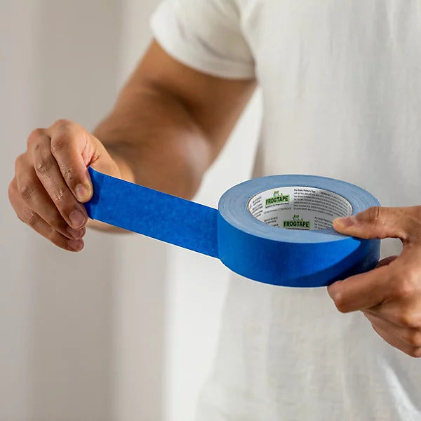 Blue masking tape being pulled from a roll