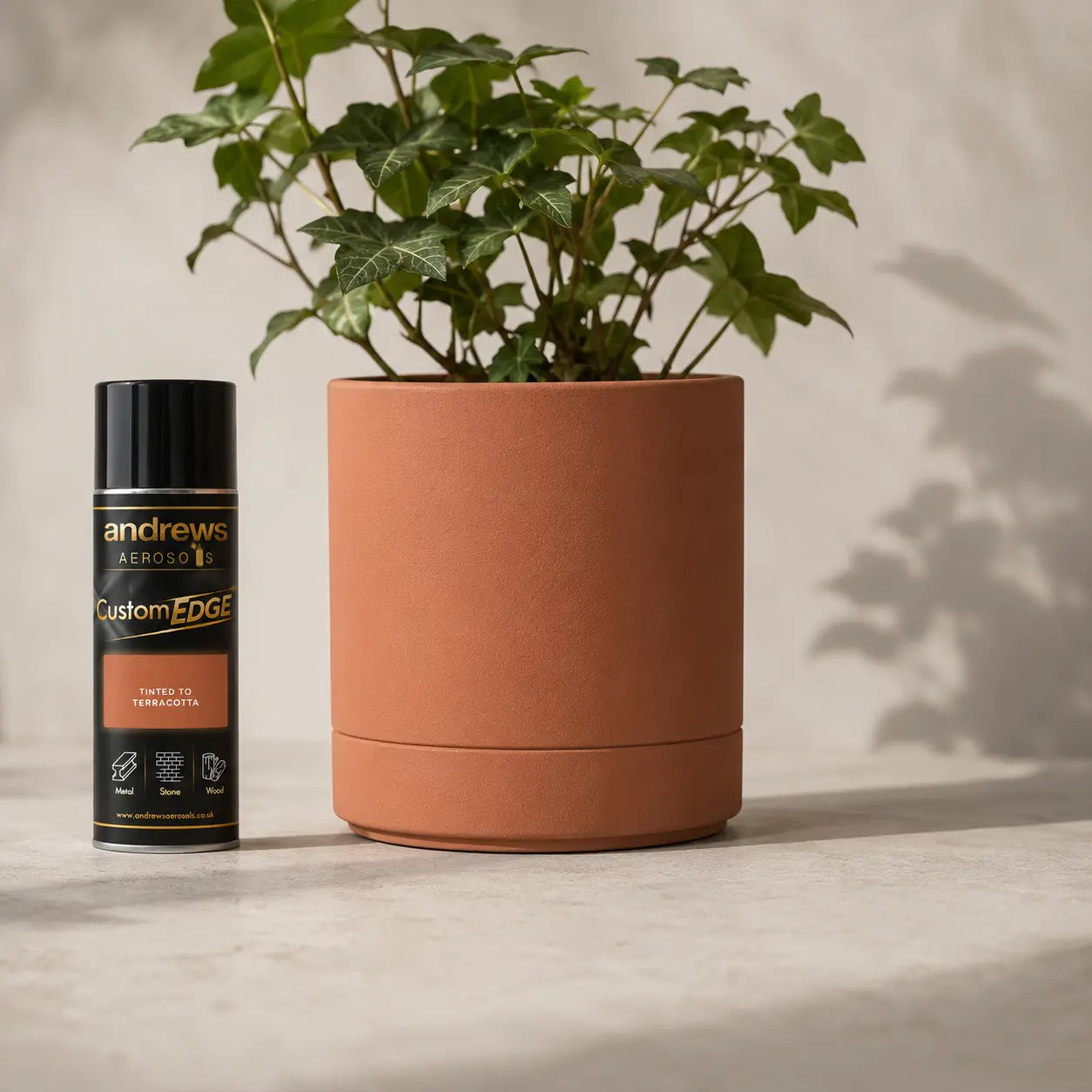 Terracotta pot with a plant and Andrews Aerosol can on a neutral background